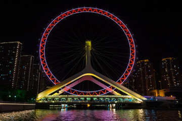 Night view of the Tianjin Eye ferris wheel on the bridge in Tianjin, China