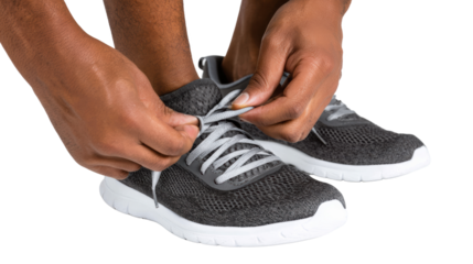 Person tying shoelaces of stylish sneakers, focus on hands and shoes.