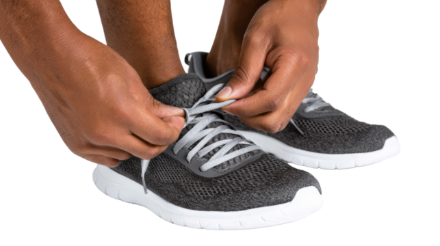 Person tying shoelaces of stylish sneakers, focus on hands and shoes.