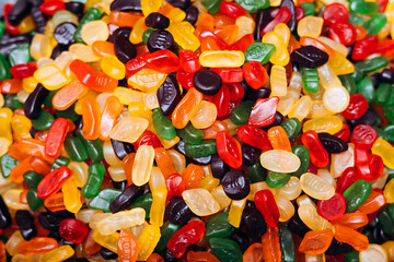 Background of colored chewing candies on the counter, vibrant sweet assortment.