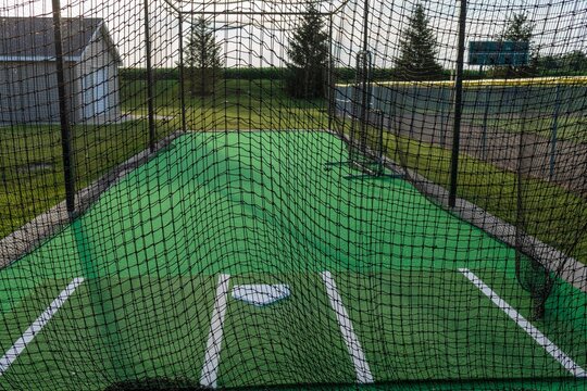 a close up of baseball batting cage on the third base side of the second field