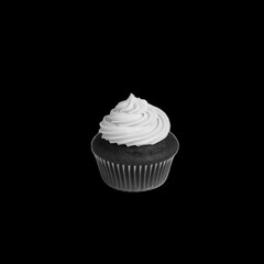 A single red velvet cupcake with white frosting isolated on a black background in a studio shot
