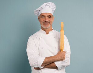 cooking, culinary and people concept - happy smiling male chef or baker in toque with rolling pin over blue