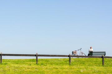 Green and blue summer day with a person and a bike. One Dutch typical summer day