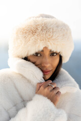 Stylish winter fashion shoot with brunette female model in snow-covered alpine landscape. Elegant...