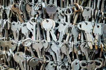 Close-up of a large collection of old metal keys tied together with wire. A textured background...