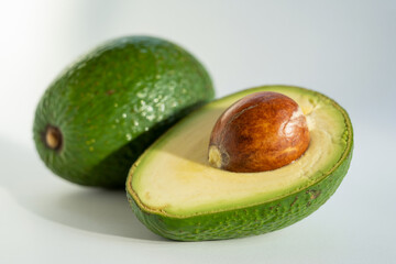 Close up of a fresh avocado cut in half isolated on white gray background