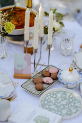 A table set with plates, candles, and delicious cookies