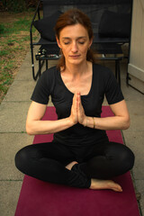 Woman meditating in lotus pose, eyes closed, finding inner peace. Perfect for capturing...