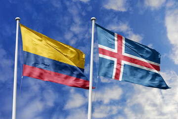 Colombia and Iceland flags proudly waving together against a brilliant blue sky, symbolizing international camaraderie, shared values, and cross-continental connections.