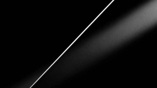 Black and white abstract background with a diagonal line in the center. the line is white and appears to be made of a smooth, shiny material.