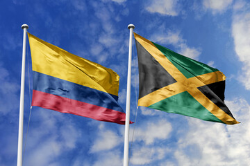 Colombia and Jamaica flags proudly fluttering against a backdrop of a vibrant blue sky, symbolizing...