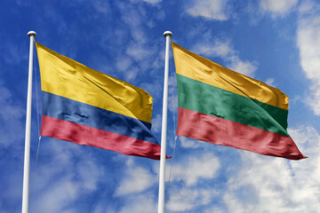 Colombia and Lithuania flags waving side by side against a vibrant blue sky, symbolizing...
