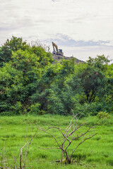 View of an excavator on a pile of rubbish from a distance, an overloaded landfill in Slamaran Pekalongan, Central Java