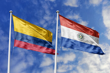 Waving flags of Colombia and Paraguay against a vibrant blue sky, symbolizing international...