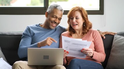 Happy couple going through their home finances at home. - Powered by Adobe