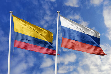 Waving flags of Colombia and Russia against a vibrant blue sky, symbolizing international relations...