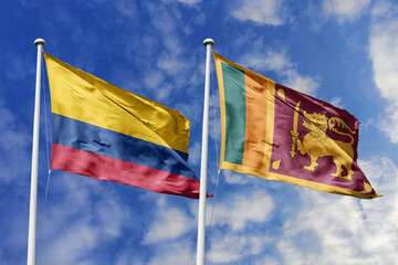 Waving flags of Colombia and Sri Lanka against a vibrant blue sky, symbolizing international...