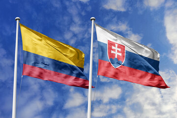 Waving flags of Colombia and Slovakia against a vibrant blue sky, symbolizing international relations and friendship.