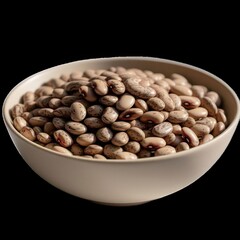 Close up shot of a bowl filled with pinto beans on a black background in a studio setting indoors