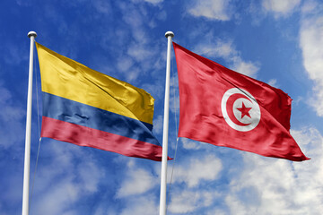 The Vibrant Flags of Colombia and Tunisia Waving Together in the Breeze Under a Bright Blue Sky,...