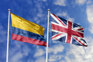 The National Flags of Colombia and the United Kingdom Waving Resiliently Together Under a Bright...