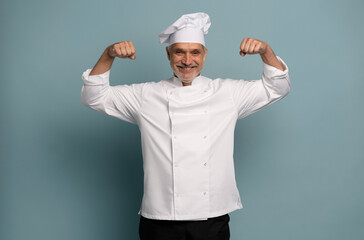 Successful emotional chef male screaming Yes and raising clenched fists in the air, feeling excited