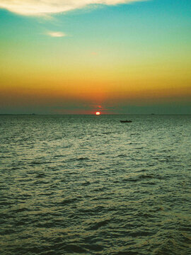 Pirogue flottant au coucher du soleil sur la mer