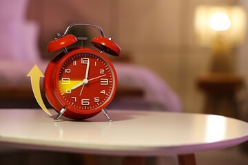 Alarm clock on table in bedroom. Spring forward concept