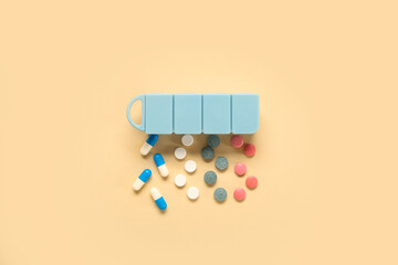 Container with different pills on yellow background