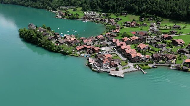 Aerial of Iseltwald at the turquoise lake Brienzersee and Castle Seeburg surrounded by its beutiful green nature in Switzerland europe also showing the filmspot pier of crash landing on you