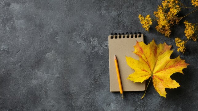 A notebook with a pencil and a leaf on top of it - Powered by Adobe