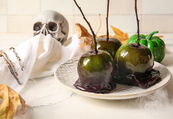 Plate of tasty caramel apples for Halloween on table