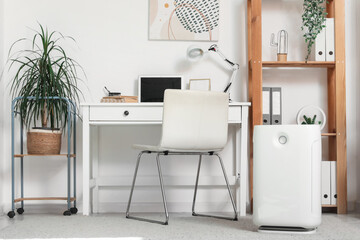 Interior of modern office with air purifier and workplace