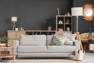 Interior of modern living room with grey sofa, lamps and shelf unit