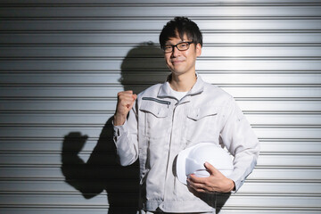 ガッツポーズする作業服の男性
