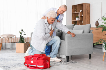 Mature man having heart attack with doctor at home