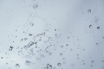 Raindrops and bubbles scatter across a wet surface, capturing nature’s freshness and moisture in...