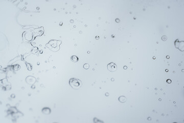 Raindrops and bubbles scatter across a wet surface, capturing nature’s freshness and moisture in...