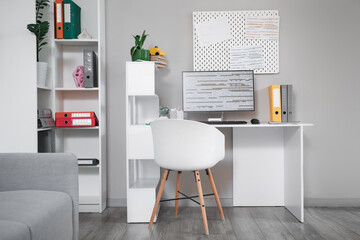 Interior of programmer's office with workplace, pegboard and shelf unit
