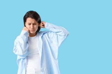 Young girl with otitis on blue background