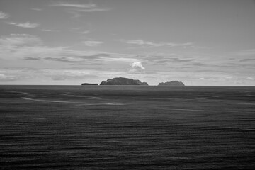 Monochrome Seascape with Distant Islands and Cloudy Sky