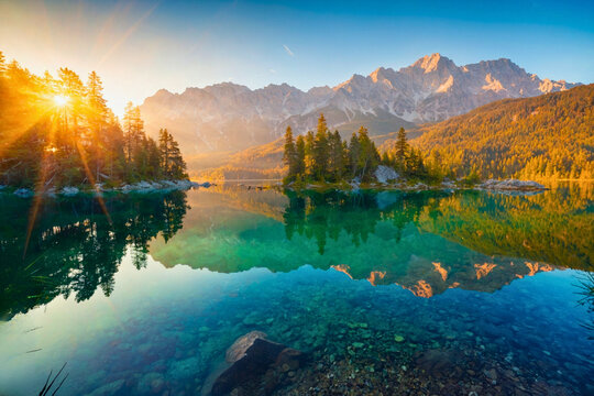 Impressive summer sunrise on Eibsee lake with Zugspitze mountain range. Sunny outdoor scene in German Alps, Bavaria, Germany, Europe. Beauty of nature concept background. - Powered by Adobe