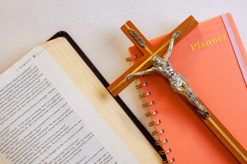 24 April 2025 Vatican City Italy Cross is positioned on an open Bible alongside daily planner in...