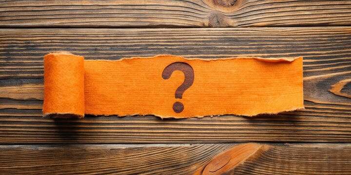 A torn orange paper strip revealing a cryptic question mark on a wooden table , wooden, enigma,  wooden, enigma, puzzle
