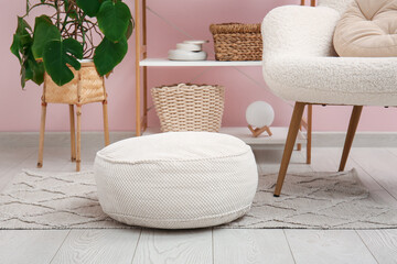 White round pouf on carpet in room