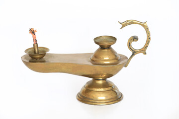 Vintage brass oil lamp with a curved, ornate handle and cotton wick, standing on a pedestal base....