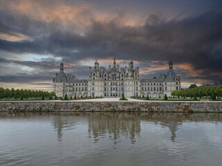 Majestic view of Château de Chambord in France under a dramatic, stormy sky, highlighting the Renaissance architecture and moody atmosphere
