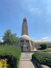 View of the Douaumont Ossuary from the military cemetery in Verdun, France, under a clear sky, commemorating World War I soldiers