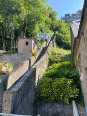 Dramatic perspective view of the steep staircase leading up to the Dinant citadel in Belgium, with stone steps and handrails under daylight.